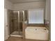 Bathroom featuring a soaking tub, walk-in shower, and ceramic tile surround at 5223 Catrina Way, Buford, GA 30519