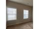 Bedroom featuring two windows with white blinds and neutral colored walls at 5223 Catrina Way, Buford, GA 30519