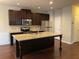 Kitchen with dark wood cabinets, granite countertops, stainless steel appliances, and a large kitchen island at 5223 Catrina Way, Buford, GA 30519