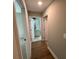 Hallway with wood floors leading to bathroom with light gray vanity at 117 Legends Way, Hiram, GA 30141