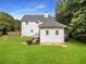A view of the home's backyard featuring a lush green lawn, deck and mature trees at 2832 Old Villa Rica Rd, Powder Springs, GA 30127