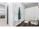 Bathroom with a toilet, a shower with a white curtain, and a wall with robes hanging on hooks at 2832 Old Villa Rica Rd, Powder Springs, GA 30127