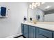 Bathroom with a blue vanity, a white countertop, a gold framed mirror, and gold hardware at 2832 Old Villa Rica Rd, Powder Springs, GA 30127