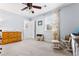Bedroom with a wooden dresser, a glider chair and ottoman, and soft lighting from a window at 2832 Old Villa Rica Rd, Powder Springs, GA 30127