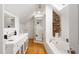 Bright bathroom featuring double vanity, skylight, glass shower, and soaking tub at 105 Parkside Cir, Decatur, GA 30030