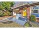 Attractive brick home entrance featuring a carport, a yellow door, and clean, modern landscaping at 3076 Cloverhurst Dr, Atlanta, GA 30344