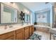 Bright bathroom with double sinks, tile surround tub, and a glass-door shower at 625 Aunt Lucy Sw Ln # 34/19, Smyrna, GA 30082