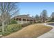 View of the community clubhouse with covered porch, manicured lawns, and mature landscaping at 625 Aunt Lucy Sw Ln # 34/19, Smyrna, GA 30082