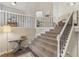 Elegant staircase with a carpet runner and decorative iron railing, connecting multiple levels at 3520 Bethwicke Dr, Cumming, GA 30040