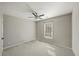 A simple bedroom with neutral carpet and walls, including a window and ceiling fan at 520 Waterside Ct, Canton, GA 30114