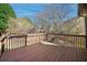 View of a wooden deck with railing overlooking the trees and landscaping in the backyard at 520 Waterside Ct, Canton, GA 30114