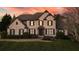 Stately brick home with a well-manicured lawn, complemented by lush landscaping and a twilight sky at 520 Waterside Ct, Canton, GA 30114