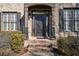 Elegant front entrance with a dark wood door, brick steps, and manicured shrubbery at 520 Waterside Ct, Canton, GA 30114