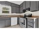 Galley kitchen featuring grey cabinets, white appliances, tile flooring and lots of natural light at 670 Westbrook Pl, Lawrenceville, GA 30044