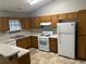 Traditional kitchen showcasing wood cabinets, white appliances, and a functional layout at 1281 Bugle Ct, Hampton, GA 30228