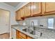Close-up of the kitchen sink and granite countertops, with wooden cabinets and stainless steel faucet at 300 Johnson Ferry Ne Rd # B411, Atlanta, GA 30328