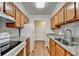Traditional galley kitchen featuring granite countertops and wood cabinets with white appliances at 300 Johnson Ferry Ne Rd # B411, Atlanta, GA 30328