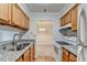 Galley kitchen boasting granite countertops and wood cabinets open to the dining area at 300 Johnson Ferry Ne Rd # B411, Atlanta, GA 30328