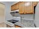 Kitchen featuring granite countertops, a white range, wooden cabinets and an exhaust fan at 300 Johnson Ferry Ne Rd # B411, Atlanta, GA 30328