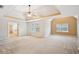 Large main bedroom showcasing tray ceilings, a ceiling fan, multiple windows, and a view into the bath at 4721 Amanda Louisa Ct, Snellville, GA 30039