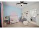 Bright Bedroom with sunrise wall decor, white crib, and comfortable gray armchair at 100 Brickworks Ne Cir # 104, Atlanta, GA 30307