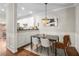 Elegant dining area with chic chandelier, wainscoting, and an open view to the kitchen at 100 Brickworks Ne Cir # 104, Atlanta, GA 30307