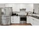 Modern kitchen showcasing stainless steel appliances, white cabinetry, and sleek black countertops at 100 Brickworks Ne Cir # 104, Atlanta, GA 30307