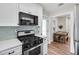 A view of the kitchen that shows white cabinets, stainless appliances and view of the dining room at 488 Park Valley Nw Dr, Atlanta, GA 30318