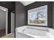 Bathroom featuring a large soaking tub beneath a bright window at 730 Reeves Lake Sw Dr, Marietta, GA 30064