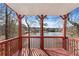 Wood deck with railing overlooking a lake surrounded by trees, offering serene views and outdoor relaxation at 730 Reeves Lake Sw Dr, Marietta, GA 30064