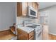 Galley kitchen with wooden cabinets, white appliances, and a gas range, with stairs and dining room in the background at 730 Reeves Lake Sw Dr, Marietta, GA 30064