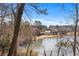 Scenic lake view showcasing a shoreline home framed by trees at 730 Reeves Lake Sw Dr, Marietta, GA 30064