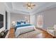 This main bedroom features a tray ceiling, hardwood floors, a balcony, and an en-suite bathroom at 730 Reeves Lake Sw Dr, Marietta, GA 30064