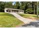 Exterior view of a charming white brick ranch home with a large driveway and green lawn at 3263 Dodson Dr, Atlanta, GA 30344