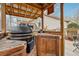 Covered outdoor BBQ area with wood counters, brick accents and stainless steel accents at 7295 Hickory Bluff Dr, Cumming, GA 30040