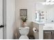 Bright bathroom featuring a standard toilet with a mirror reflection of a tub at 7295 Hickory Bluff Dr, Cumming, GA 30040