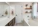 Bright bathroom featuring a bathtub, floating shelves, and vanity with plenty of counter space at 7295 Hickory Bluff Dr, Cumming, GA 30040