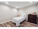 Well-lit bedroom featuring elegant hardwood flooring, a bed, and a dresser at 7295 Hickory Bluff Dr, Cumming, GA 30040