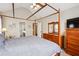 Light-filled bedroom with wood canopy bed, wood dresser, and ensuite bathroom entrance at 7295 Hickory Bluff Dr, Cumming, GA 30040