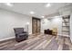 Finished basement living room with dark wood-look flooring and barn door accent at 7295 Hickory Bluff Dr, Cumming, GA 30040