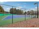 Well maintained tennis court with green and blue surface and sturdy fencing at 7295 Hickory Bluff Dr, Cumming, GA 30040