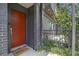 Close-up of a bright orange front door with stylish hardware and a welcoming 'HELLO' doormat at 1145 Kirkwood Se Ave # 4, Atlanta, GA 30316
