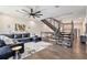 Open living room with a modern staircase, dark sofa, sleek ceiling fan, and stylish decor at 1145 Kirkwood Se Ave # 4, Atlanta, GA 30316