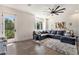 Spacious living room with large windows, dark leather sectional, ceiling fan, and stylish decor for a modern feel at 1145 Kirkwood Se Ave # 4, Atlanta, GA 30316