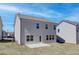 A spacious backyard featuring a concrete patio and views of neighboring homes under a clear blue sky at 706 Bristol Dr, Loganville, GA 30052
