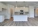 Open kitchen with island, stainless steel appliances, granite countertops, and white cabinets at 706 Bristol Dr, Loganville, GA 30052