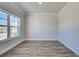 Well-lit room with wood-look floors, white trim, and a large window offering bright light and outdoor views at 706 Bristol Dr, Loganville, GA 30052