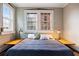 Bedroom featuring exposed brick, a large window, and hardwood flooring at 93 Peachtree Ne Pl # 5, Atlanta, GA 30309