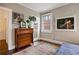 Bedroom featuring a large window, exposed brick, hardwood flooring and dresser at 93 Peachtree Ne Pl # 5, Atlanta, GA 30309