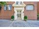 Classic brick building entrance with elegant glass paned doorway, framed by well-manicured greenery at 93 Peachtree Ne Pl # 5, Atlanta, GA 30309